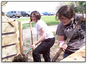 Girls turning compost